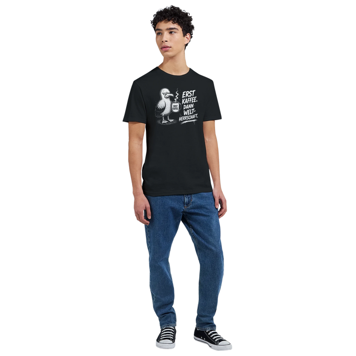 Ganzkörperansicht: junger Mann in schwarzem T-Shirt mit Möwen-Print, Jeans und Sneakers, Studio