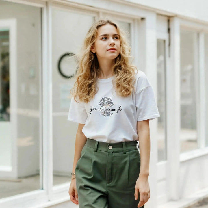 Frau mit grüner Hose trägt weißes T-Shirt mit Schriftzug &