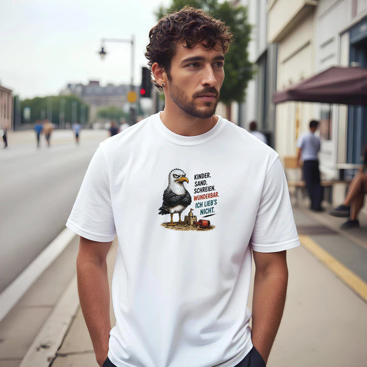 Mann mit lockigem Haar trägt das weiße T-Shirt in einer Straßenszene, Möwen-Print mit Spruch „Ich lieb&