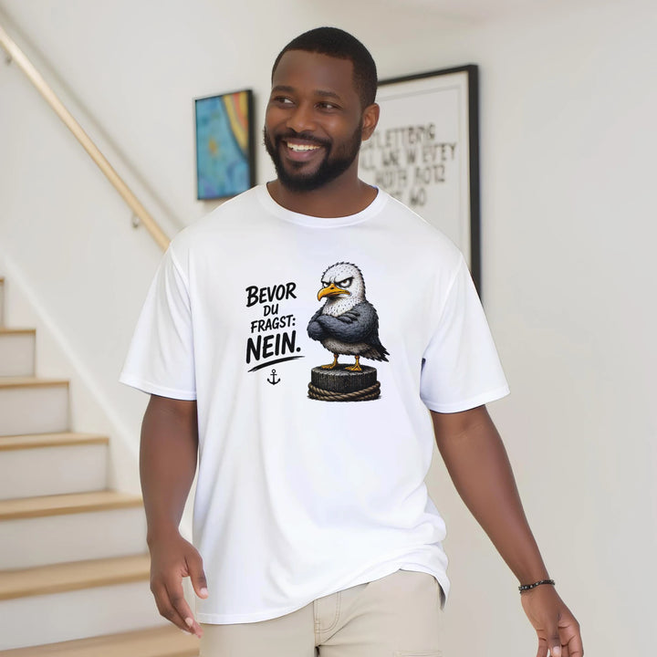 Lächelnder Mann trägt das T-Shirt locker im Wohnbereich mit Treppe