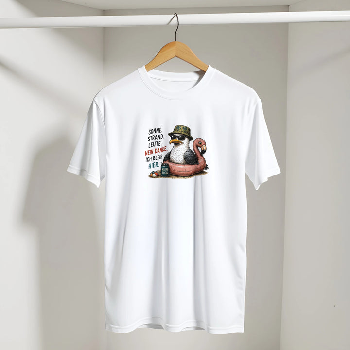 Weißes T-Shirt mit Möwen-Print hängt an einem Bügel vor heller Wand mit Schattenwurf.