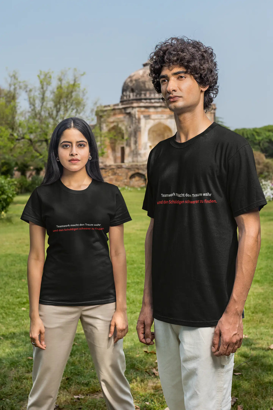 Mann und Frau tragen gemeinsam schwarze „Teamwork“-T-Shirts vor historischem Gebäude