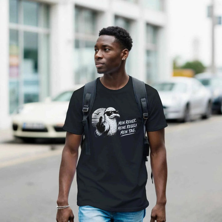 Mann mit Rucksack trägt schwarzes Möwen-Shirt beim Spaziergang durch die Stadtstraße
