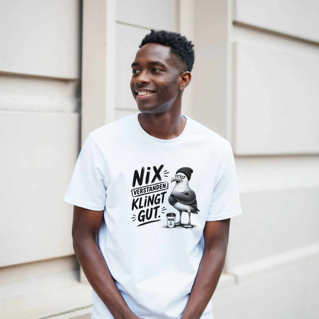 Lächelnder Mann im T-Shirt mit grummeliger Möwe, Porträt vor einer Hauswand