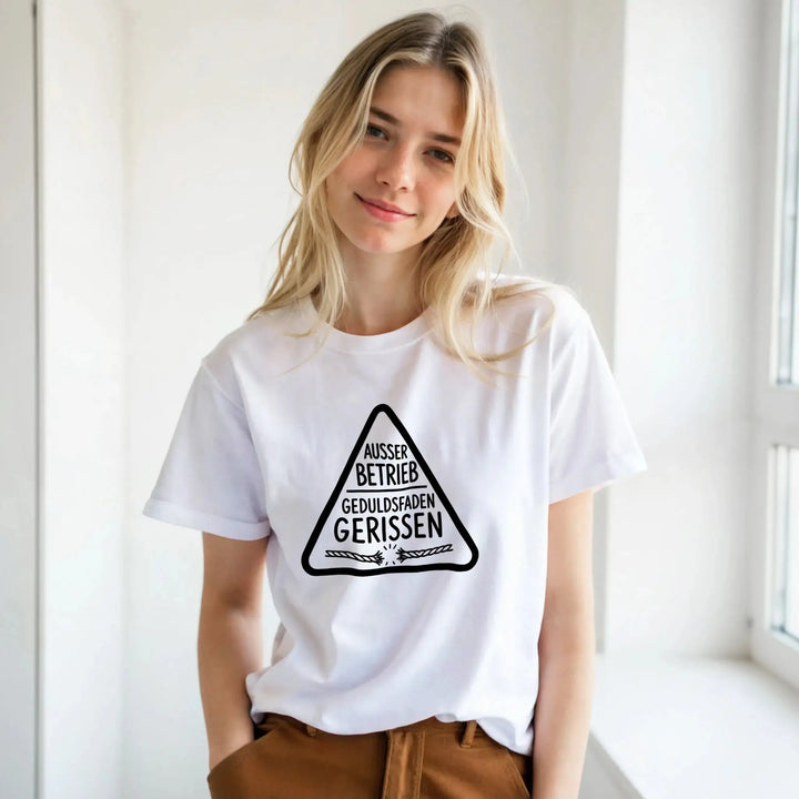 Junge Frau am Fenster trägt weißes „Geduldsfaden gerissen“ T-Shirt
