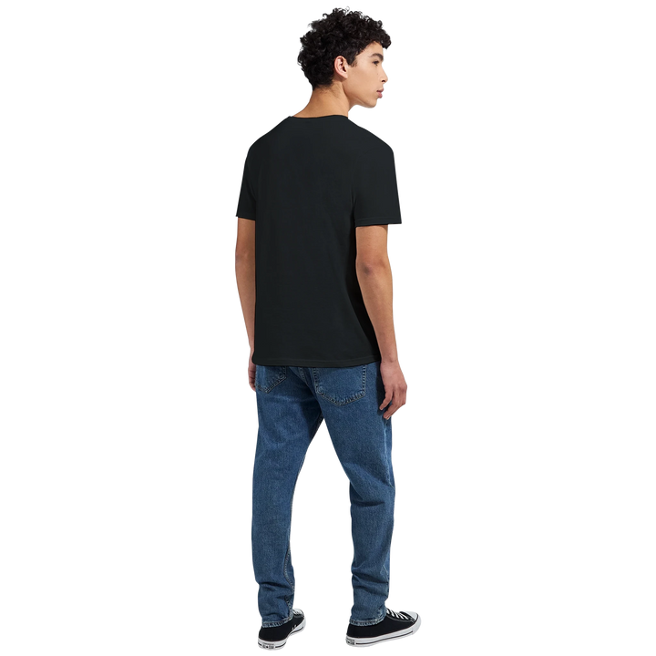 Rückansicht: Mann mit lockigem Haar im schwarzen T-Shirt ohne Aufdruck, kombiniert mit blauer Jeans.