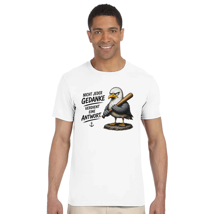 Lächelnder Mann im weißen T-Shirt mit Möwen-Motiv, Nahaufnahme vor hellem Studiohintergrund.