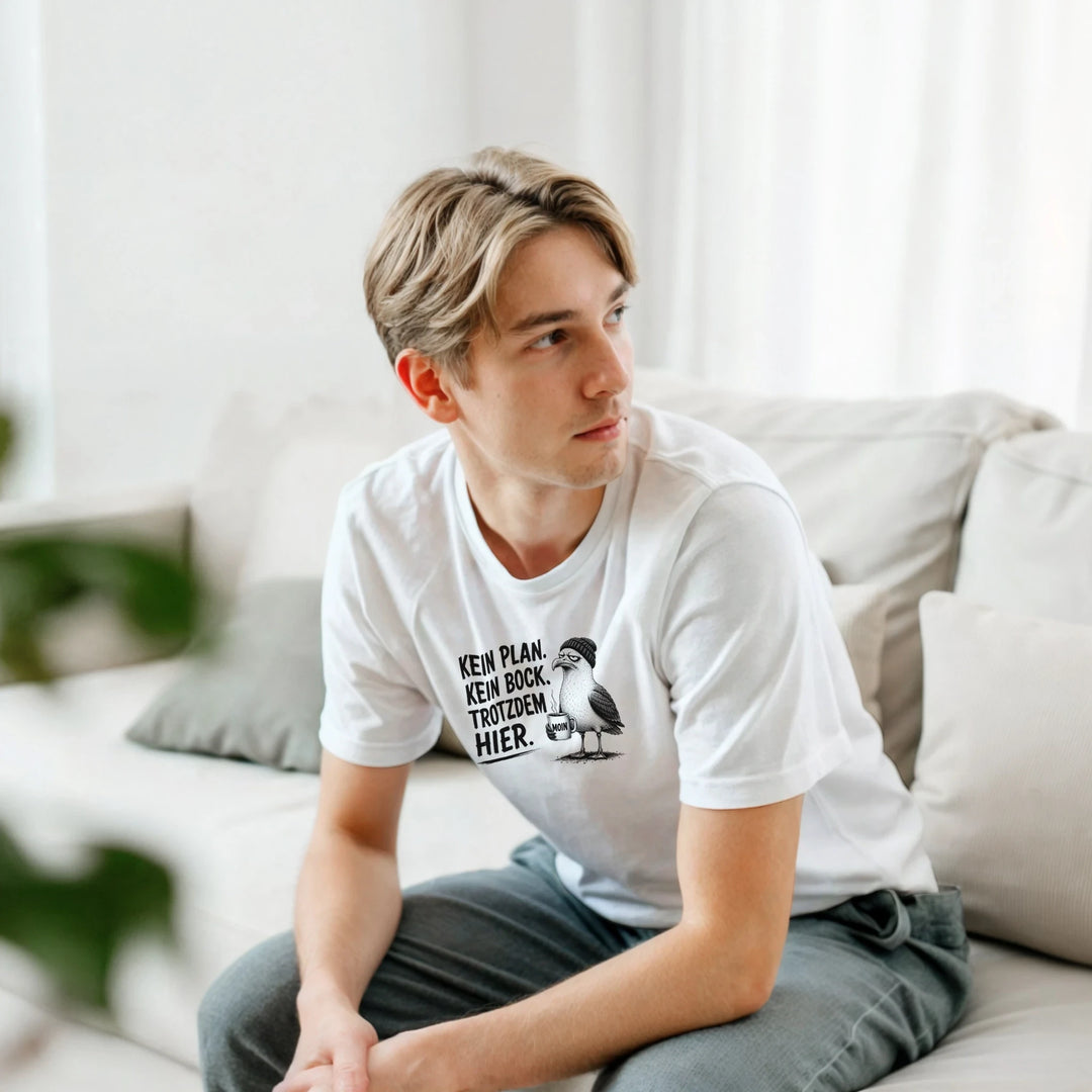 Junger Mann sitzt entspannt auf dem Sofa, weißes T-Shirt mit Spruch-Print