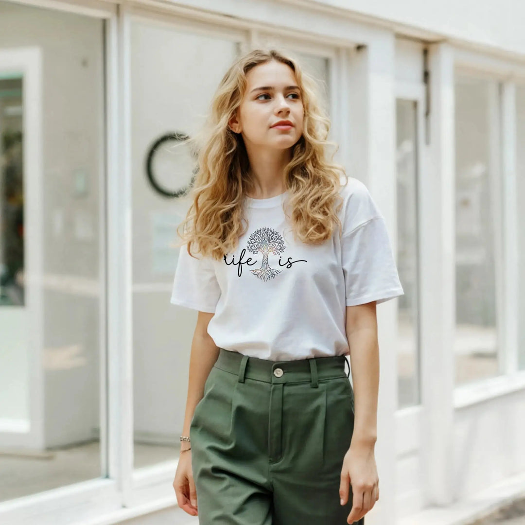 Frau mit grüner Hose trägt weißes T-Shirt mit &