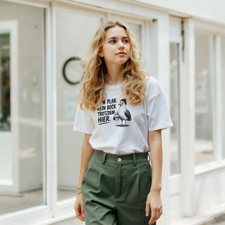 Junge Frau in grüner Hose vor Schaufenster, weißes T-Shirt mit Spruch-Print