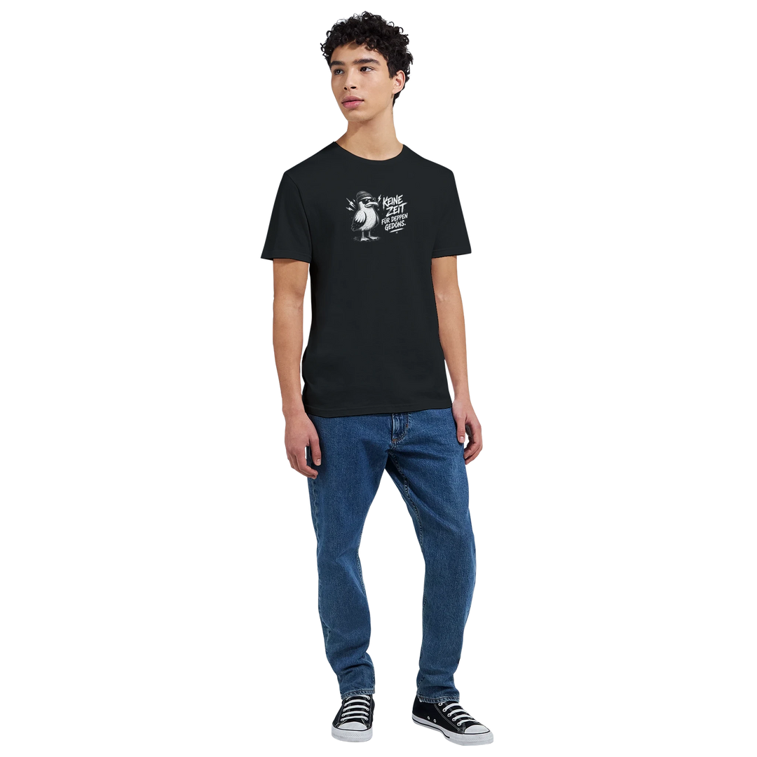 Ganzkörperaufnahme eines Mannes in Jeans und Sneakers, schwarzes T-Shirt mit Möwen-Print auf der Brust vor hellem Hintergrund.