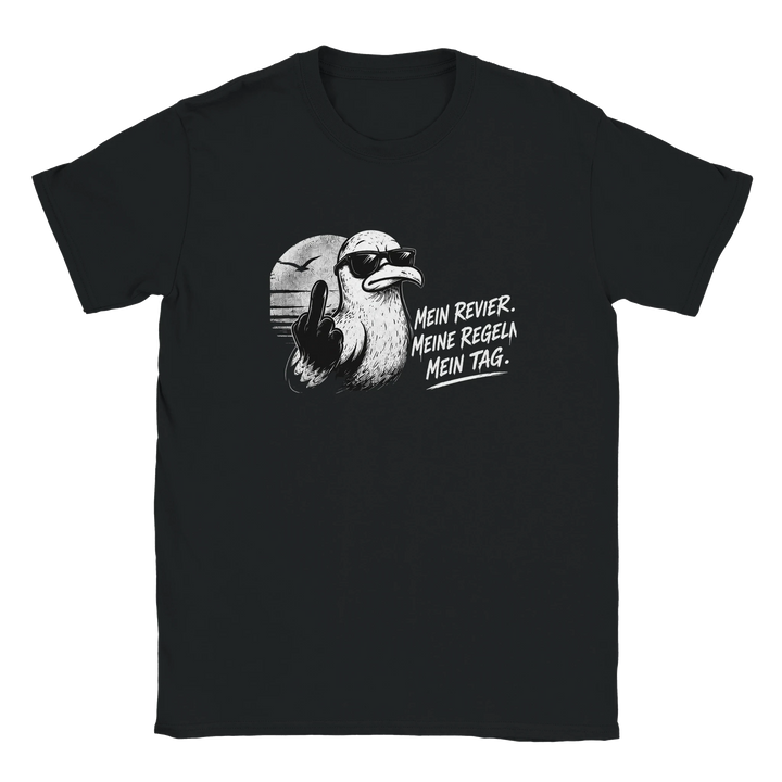 Flatlay des schwarzen T-Shirts mit Möwe im Sonnenuntergang und Spruch „Mein Revier. Meine Regeln. Mein Tag.“