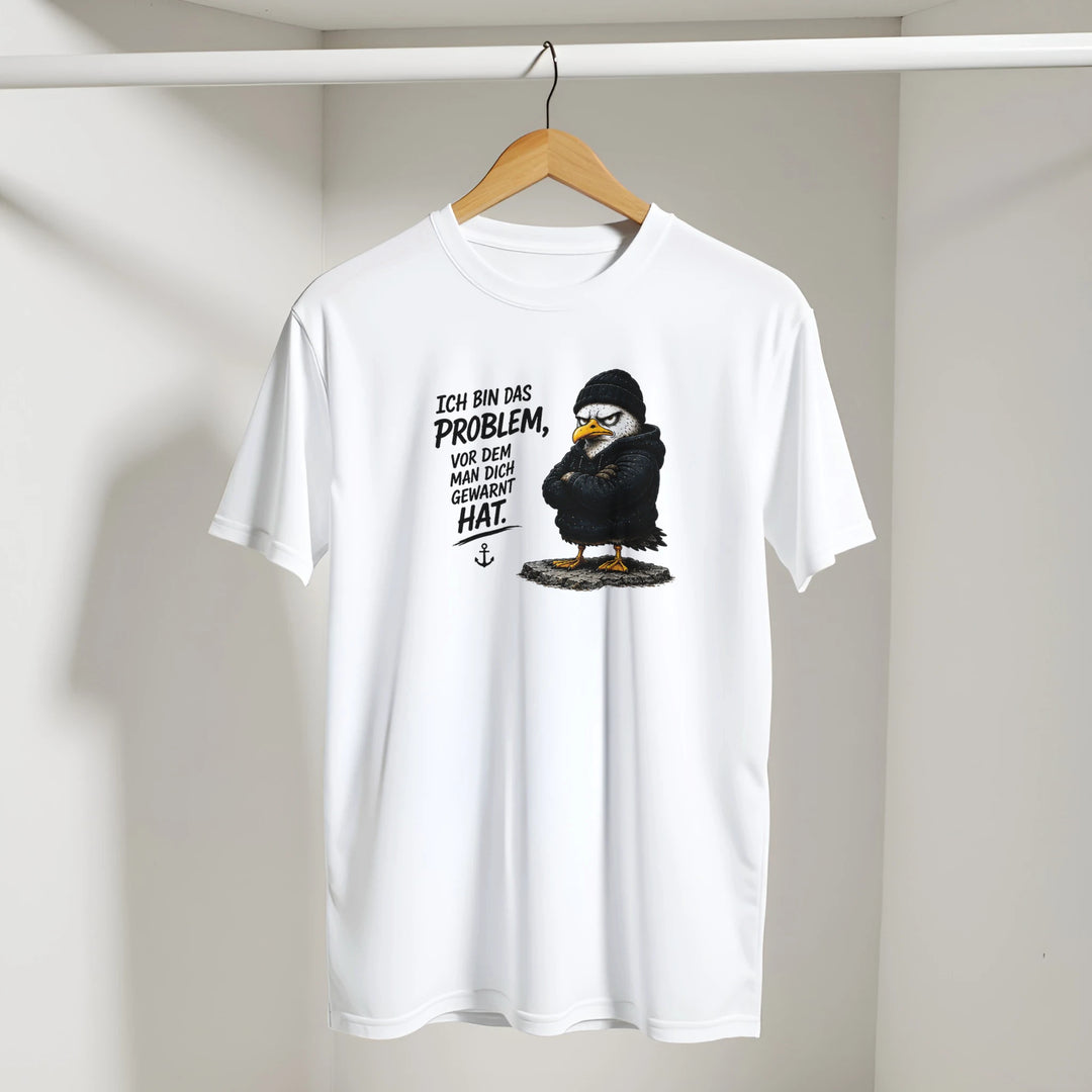 T-Shirt mit Vogel-Print hängt an Kleiderstange in hellem Raum