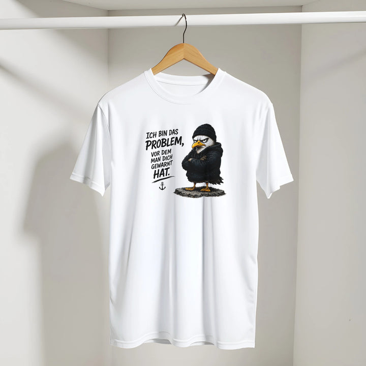 T-Shirt mit Vogel-Print hängt an Kleiderstange in hellem Raum