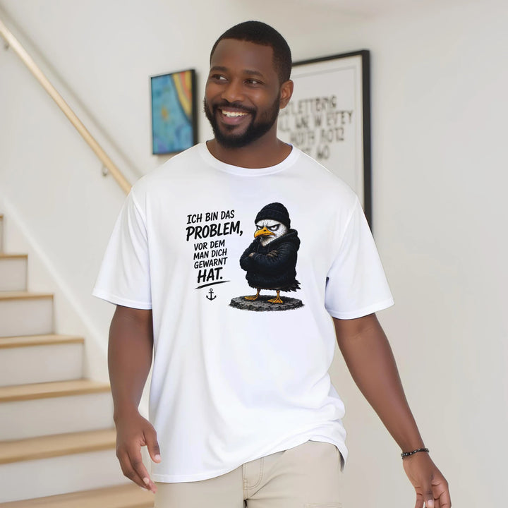 Lächelnder Mann trägt das T-Shirt locker im Wohnbereich mit Treppe