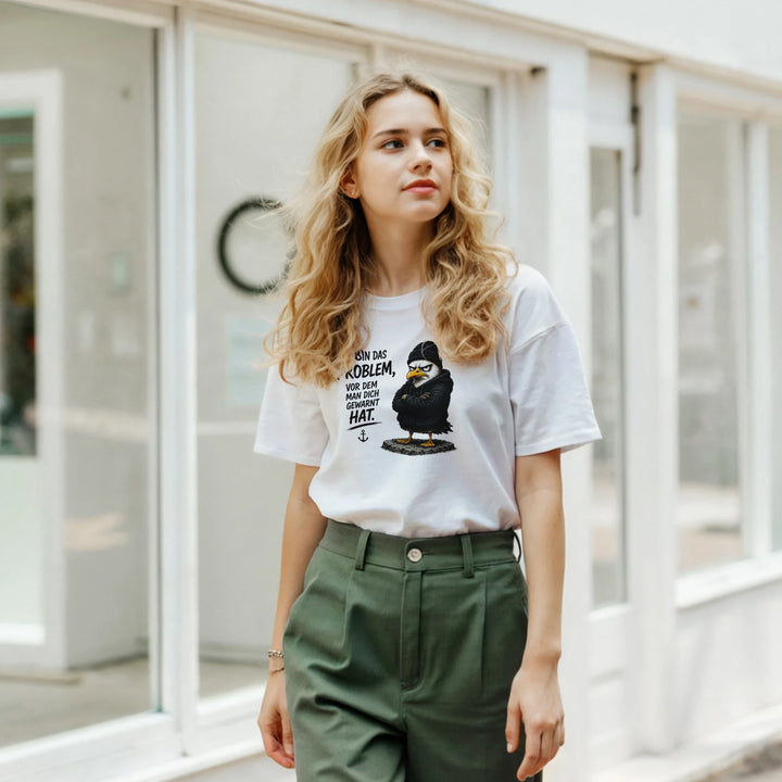 Frau trägt das T-Shirt mit Vogel-Print vor einem Schaufenster in der Stadt