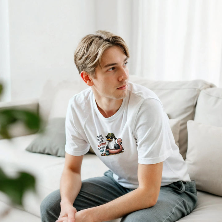 Blonder Mann sitzt seitlich auf einer Couch und trägt das weiße T-Shirt mit Möwen-Print.