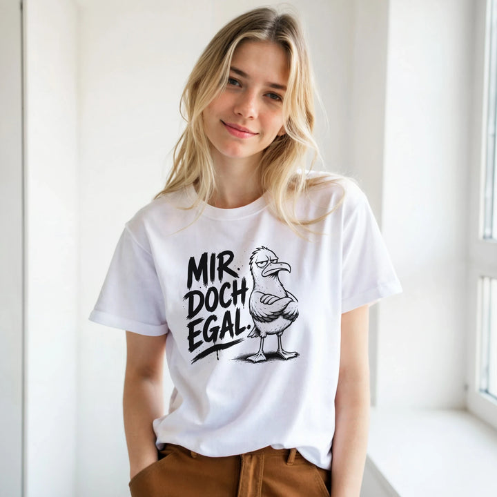 Blonde Frau am Fenster lächelt, weißes T-Shirt mit Möwen-Print, braune Hose