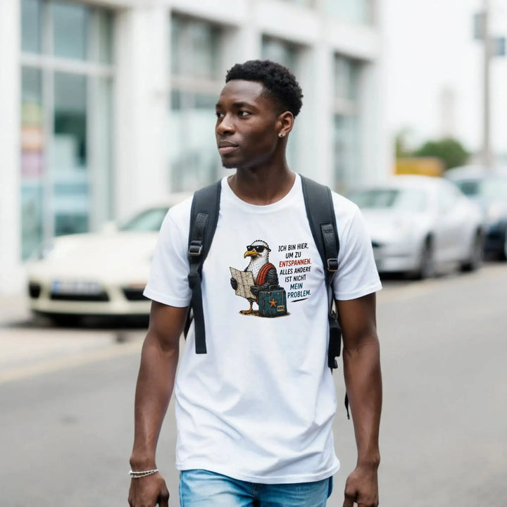 Mann mit Rucksack trägt das weiße Möwen-Shirt beim Stadtspaziergang, Autos im Hintergrund.