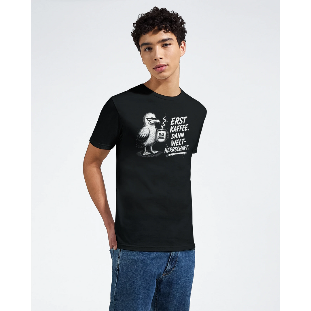 Nahaufnahme: junger Mann im schwarzen T-Shirt mit Möwe und Kaffeetasse-Print im Studio