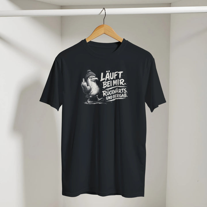 Schwarzes T-Shirt mit Möwen-Print an einem Holzbügel hängend in einer Umkleide.