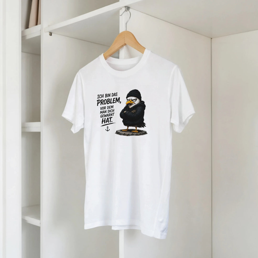 T-Shirt mit Vogel-Motiv hängt am Kleiderbügel im offenen Kleiderschrank
