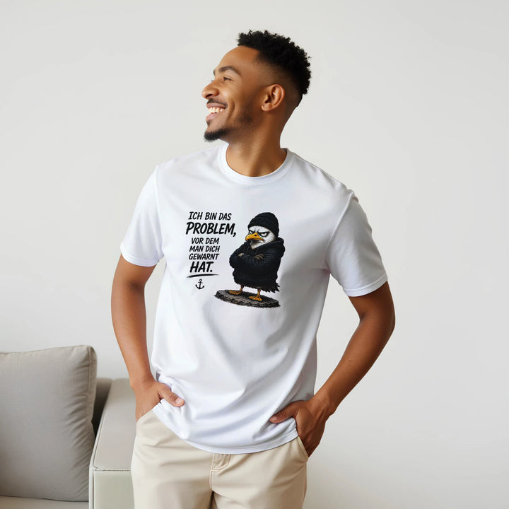 Lachender Mann im weißen T-Shirt steht neben grauem Sofa im Wohnzimmer