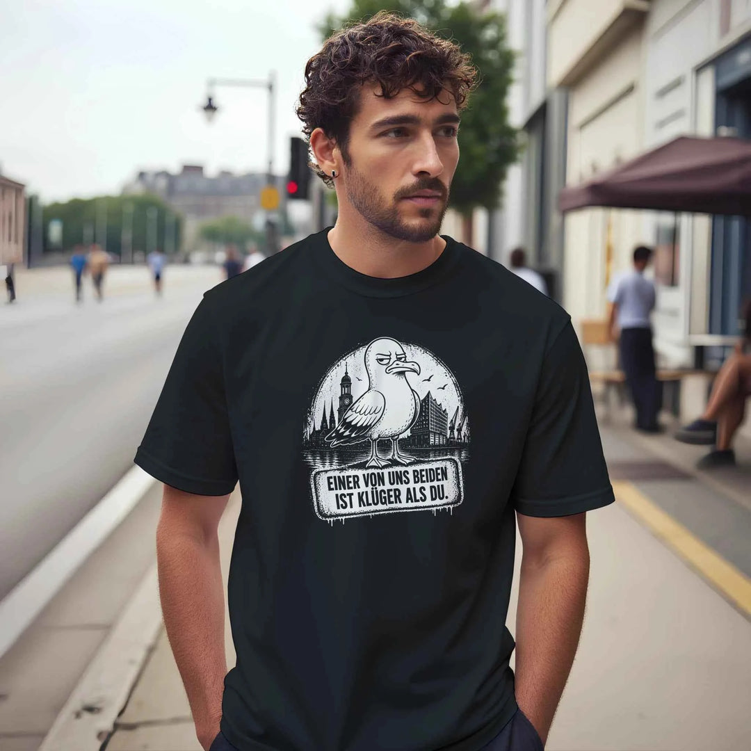 Bärtiger Mann trägt das Shirt mit Möwe und Hamburg-Skyline auf einer Straße mit unscharfem Hintergrund.