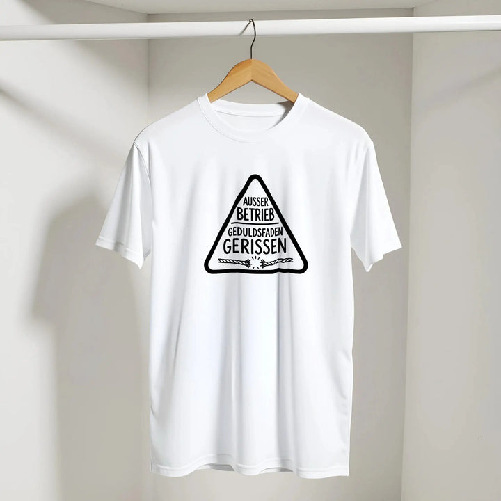 Weißes „Geduldsfaden gerissen“ T-Shirt hängt am Kleiderbügel vor grauer Wand