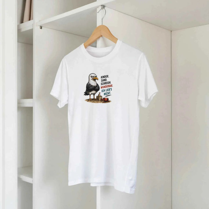 Weißes T-Shirt mit Möwen-Motiv hängt am Kleiderbügel im Schrank, Spruch „Kinder. Sand. Schreien. Wunderbar.“
