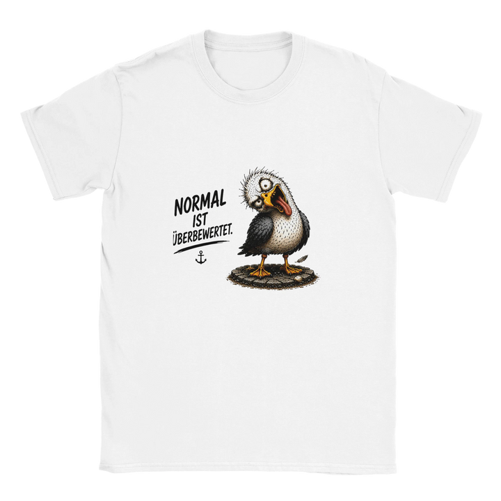 Flatlay des weißen T-Shirts mit schräger Möwe und Schriftzug „Normal ist überbewertet.“ auf grauem Hintergrund