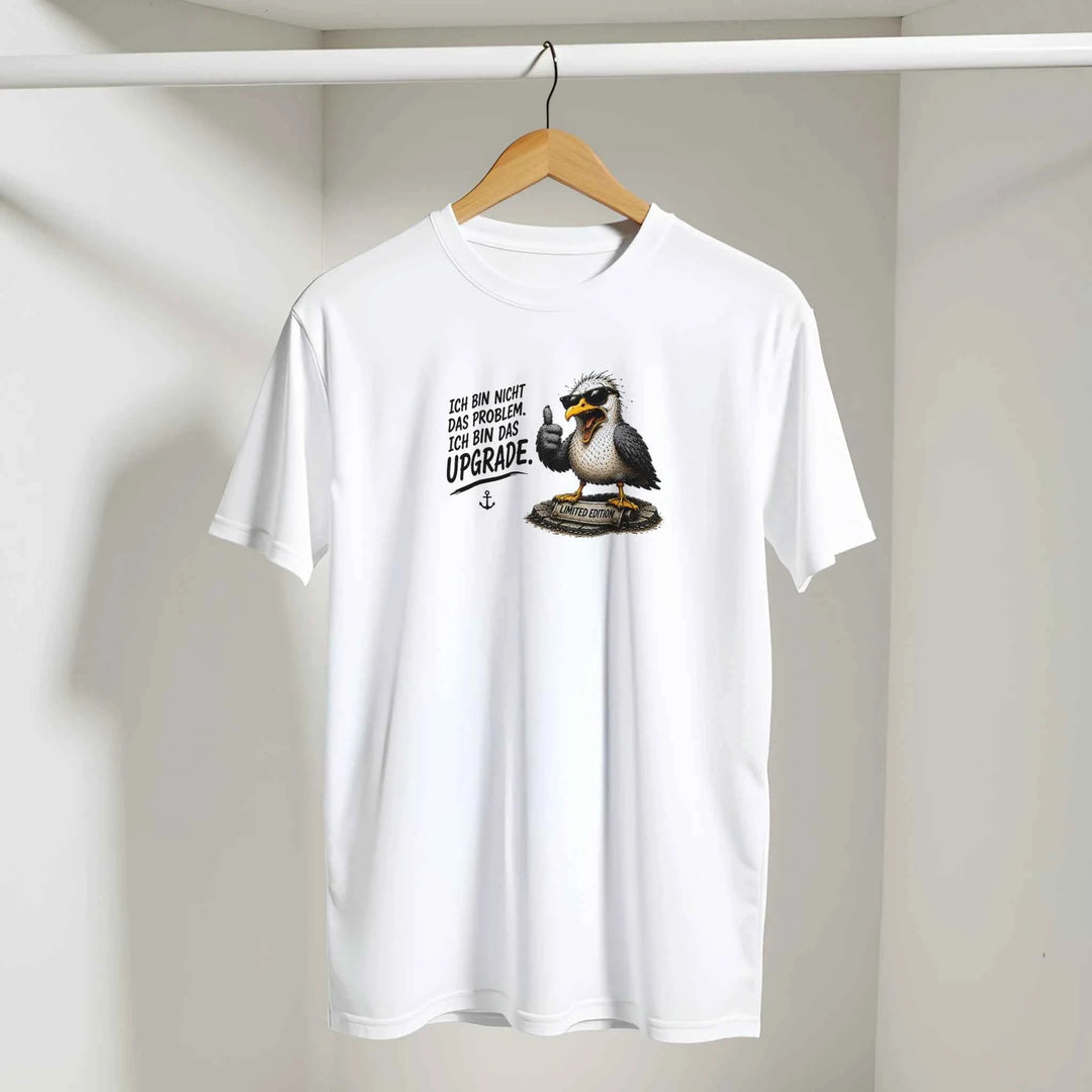 Weißes T-Shirt mit Möwen-Print auf einem Kleiderbügel vor heller Wand hängend