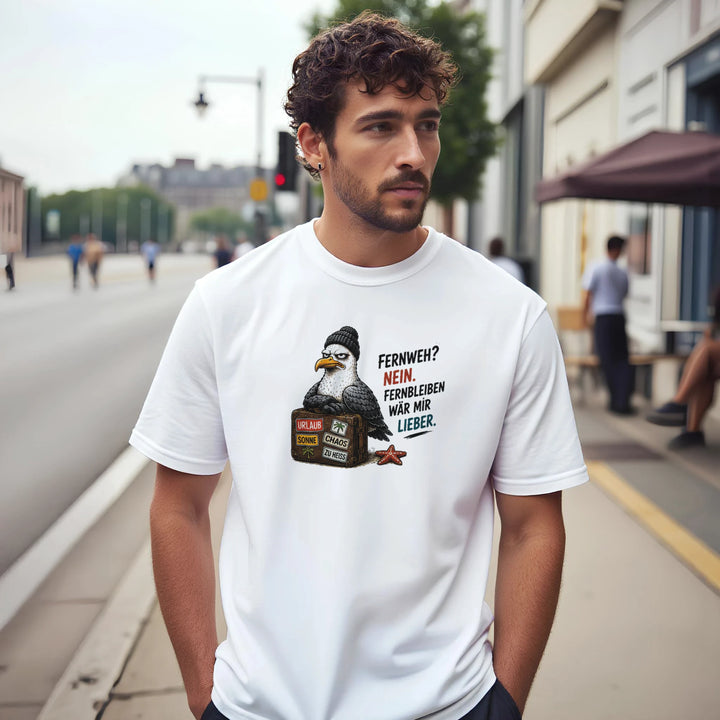 Mann steht mit Händen in den Taschen auf der Straße, trägt das weiße T-Shirt mit grimmiger Möwe und Koffer-Print.
