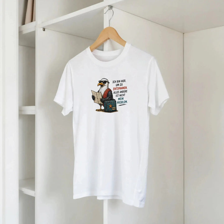 Weißes T-Shirt mit Möwen-Print hängt auf Holzbügel im Kleiderschrank.