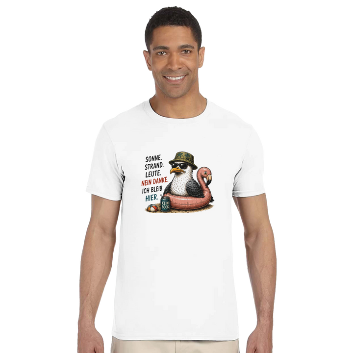Lächelnder Mann im weißen T-Shirt mit Möwen-Print vor weißem Studiohintergrund, kombiniert mit beiger Hose.