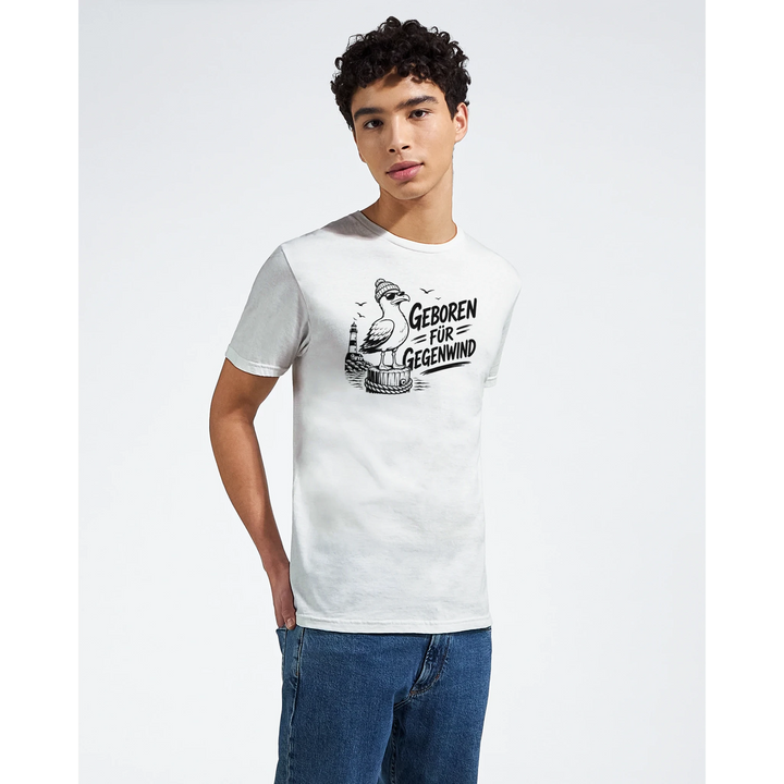 Junger Mann im cremefarbenen T-Shirt mit Möwen-Design, Halbkörper-Studiofoto