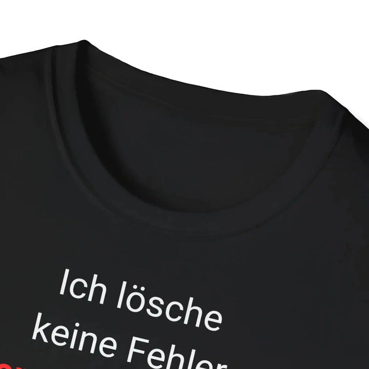 Nahaufnahme von Kragen und oberer Textzeile „Ich lösche keine Fehler.“ auf dem schwarzen Entwickler-Shirt.
