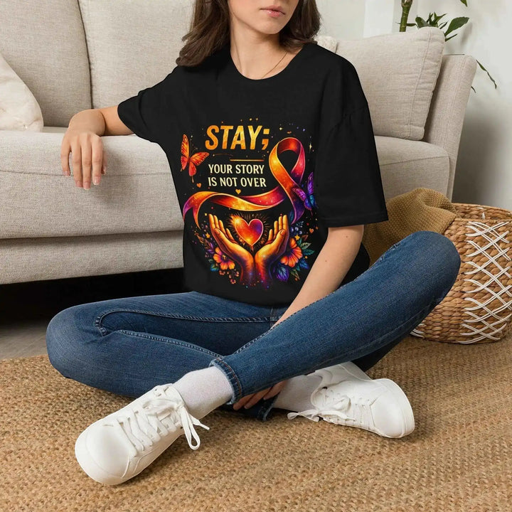 KlareAnsage schwarzes Baumwoll-T-Shirt mit buntem Your Story Is Not Over Aufdruck, getragen von einer Frau.