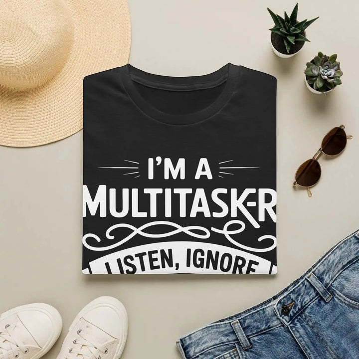 Schwarzes Multitasker-T-Shirt als Flatlay zwischen Sonnenhut, Sonnenbrille, Turnschuhen und Jeans.