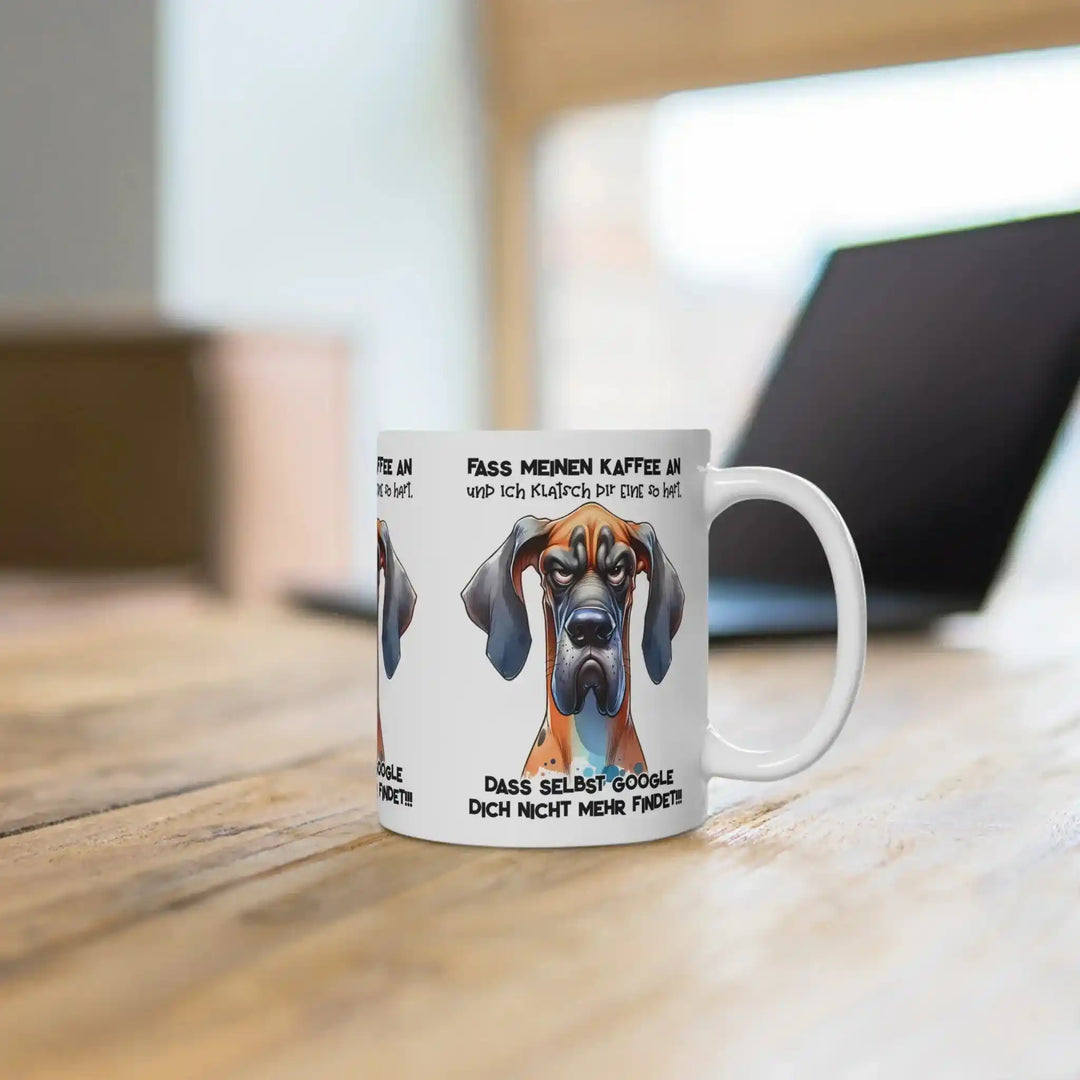 Hunde-Tasse mit Aufdruck auf einem Holzschreibtisch, im Hintergrund ein unscharfer Laptop